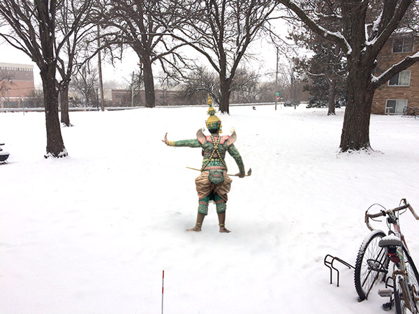 a colorfully costumed individual standing barefoot in the snow