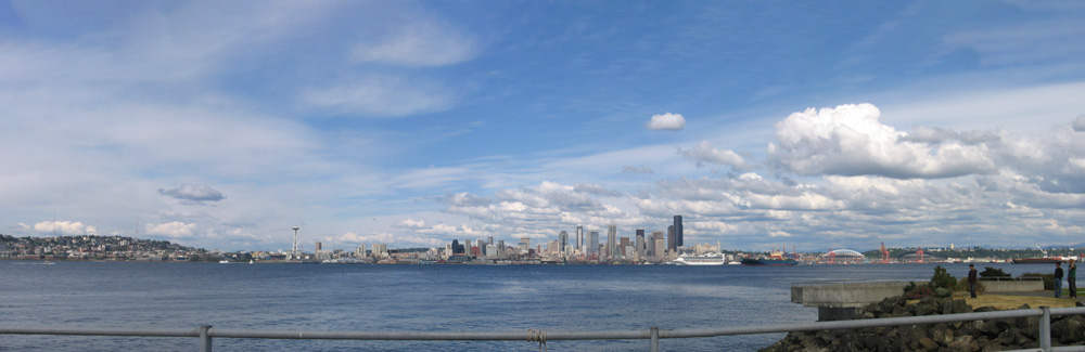 a view from a bridge of a body of water with a city toward the horizon