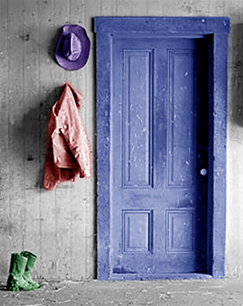 A wall with a doorway with a hat and jacket hanging from it, a pair of boots on the floor